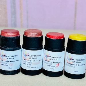 Pu&ograve; includere: Quattro balsami per labbra di diversi colori in tubi neri con etichette bianche. Le etichette riportano "Ultra Hydrating Lip Balm" con il nome del marchio "Skinvictuals" e il sapore di ogni balsamo. I sapori sono Pearl Pink, Warm Nude, Raspberry e un balsamo giallo semplice.