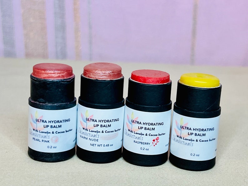 Pu&ograve; includere: Quattro balsami per labbra di diversi colori in tubi neri con etichette bianche. Le etichette riportano "Ultra Hydrating Lip Balm" con il nome del marchio "Skinvictuals" e il sapore di ogni balsamo. I sapori sono Pearl Pink, Warm Nude, Raspberry e un balsamo giallo semplice.