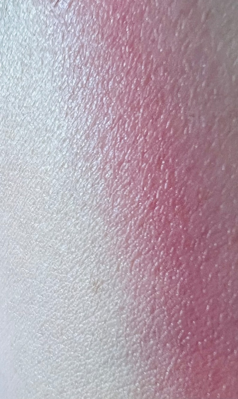 Pu&ograve; includere: Primo piano di un ombretto sfumato con una transizione di colore dal bianco al rosa. L'ombretto ha una finitura scintillante.