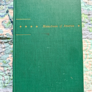 May include: A hardcover book with a green cover. The title "Mainstream of America" is printed in gold, along with five gold stars. The book has a textured appearance.