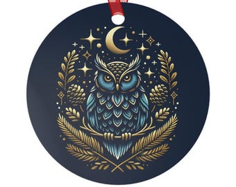 May include: Round Christmas ornament with a dark blue background and a detailed owl design. The owl is in shades of blue and teal, with gold accents. The design includes a crescent moon, stars, and gold foliage. A red ribbon is attached for hanging.