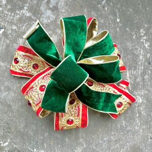 以下が含まれることがあります： 緑色のベルベットの中央とアクセントが特徴的な、お祝いのクリスマスリボン。赤い宝石の装飾が施された、赤と金の模様のリボンが特徴です。休日の装飾用の装飾要素です。