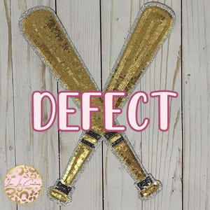 May include: Two gold sequined baseball bats crossed over each other. The bats are silver on the edges and have black trim. The word "DEFECT" is written in pink letters across the center of the image.
