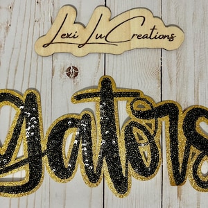 May include: Black and gold sequined iron-on patch that says "Gators".