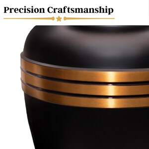 May include: Black urn with a gold trim around the top. The urn has a smooth, polished finish.