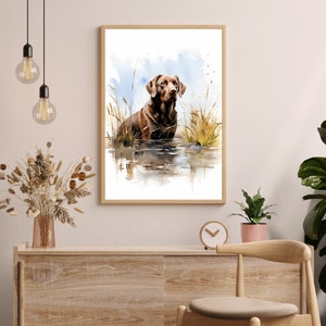 May include: Watercolor painting of a brown Labrador Retriever standing in a body of water with tall grass in the background.