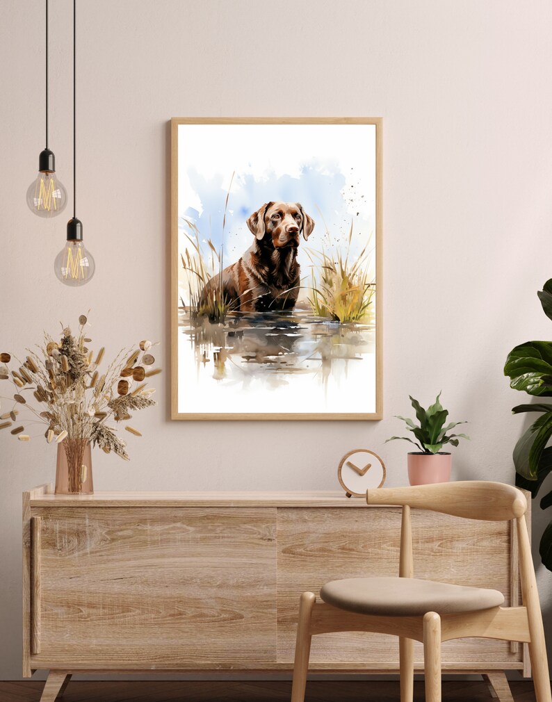 May include: Watercolor painting of a brown Labrador Retriever standing in a body of water with tall grass in the background.