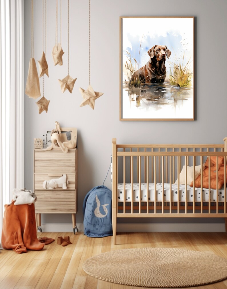 May include: A watercolor painting of a brown Labrador Retriever standing in a body of water with tall grass on either side. The painting is framed in a light wood frame and hanging on a white wall.