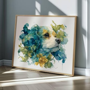 May include: A framed watercolour painting of a dog's head, featuring white, tan, and brown fur, with blue and green floral accents. The gold-framed artwork leans against a wall, showcasing the art piece.