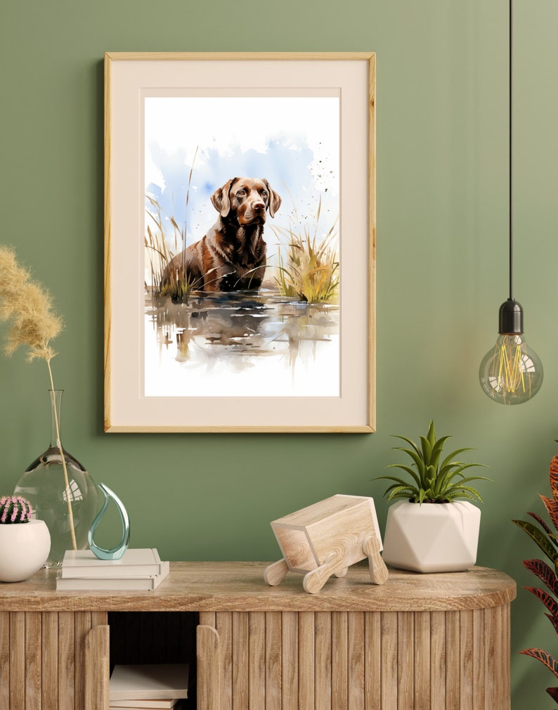 May include: Watercolor painting of a brown Labrador Retriever standing in a body of water with tall grass in the background.