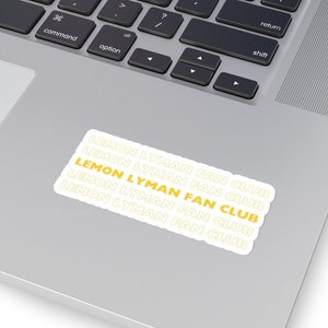May include: A white sticker with the text "LEMON LYMAN FAN CLUB" repeated five times in a stacked format. The text is in a yellow color with a white outline.