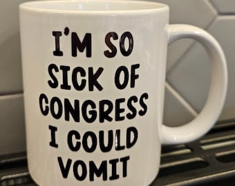 Puede incluir: Taza de café de cerámica blanca con un gráfico negro que dice "Estoy tan harto del Congreso que podría vomitar."