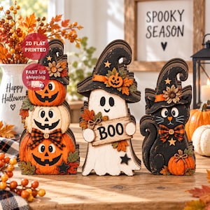 Könnte beinhalten: Drei Halloween-Holzdekorationen bestehend aus einem Stapel aus drei Kürbissen, einem weißen Geist mit Hexenhut, der ein Schild mit der Aufschrift BOO hält, und einer schwarzen Katze mit Hexenhut, karierter Schleife und einem kleinen orangefarbenen Kürbis.