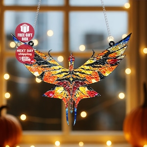 May include: A stained glass bird ornament with outstretched wings, featuring a vibrant mosaic of orange, yellow, black, and blue hues. The ornament hangs from a chain, with the text "FREE GIFT BOX" and "NEXT DAY shipping" visible.