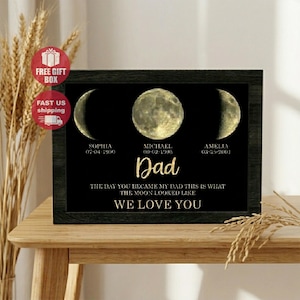 May include: A framed black print with three moon phases, personalized with names, dates, and the word "Dad." The text reads "The day you became my dad this is what the moon looked like. We love you."