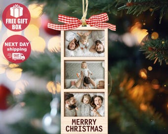 May include: A rectangular wooden photo ornament featuring three stacked portrait frames containing family photographs, topped with a red and white gingham ribbon and a jute twine hanger, with the text MERRRY CHRISTMAS printed at the bottom.