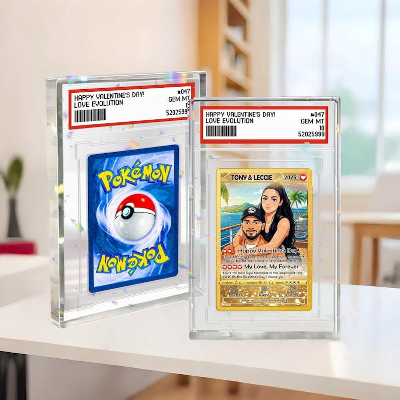 May include: Two graded trading cards in clear cases. One features a Pok&eacute;mon card with a blue background and a Pok&eacute; Ball. The other card has a couple's portrait with the text "Happy Valentine's Day! Love Evolution".