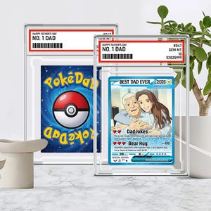 May include: Two framed trading cards. One features a blue and red Pokeball design with "Pok&eacute;Dad" text. The other card reads "Happy Father's Day No. 1 Dad" and "Best Dad Ever 2026" with an illustration of a father and daughter. Both cards are in protective cases.