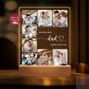 Könnte beinhalten: Eine personalisierte Fotoanzeige mit Holzsockel und leuchtendem Rahmen. Die Anzeige zeigt mehrere Familienfotos und den Text "we love you dad" mit Namen darunter. Das Produkt wird mit warmem Licht beleuchtet.