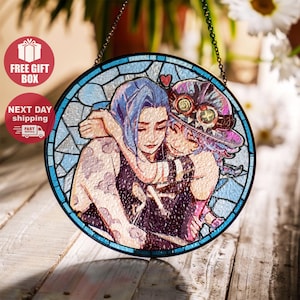 Puede incluir: Arte de ventana de vidriera redonda que representa a dos figuras abrazándose. La obra de arte tiene una combinación de colores azul y morado, con una cadena para colgar. La imagen incluye las palabras "FREE GIFT BOX" y "NEXT DAY shipping".