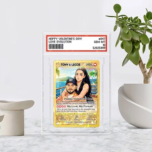 May include: A custom Valentine's Day card featuring a couple, with the text "Happy Valentine's Day!" and "My Love, My Forever." The card is encased in a clear protective holder. The card has a gold background and a tropical beach scene.