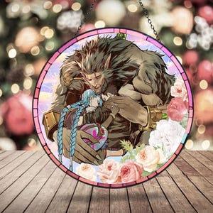 May include: Round stained glass art piece featuring a detailed illustration of a large, furry character embracing two smaller figures. The artwork is framed with a pink border and surrounded by floral accents, with a hanging chain.