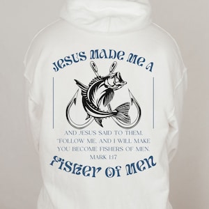 Könnte beinhalten: Weißer Hoodie mit einer schwarz-weißen Grafik eines Fisches an einem Haken. Der Text "JESUS MADE ME A FISHER OF MEN" ist in Blau auf dem Hoodie gedruckt. Der Text "MARK 1:17" ist in Blau unter der Grafik gedruckt.