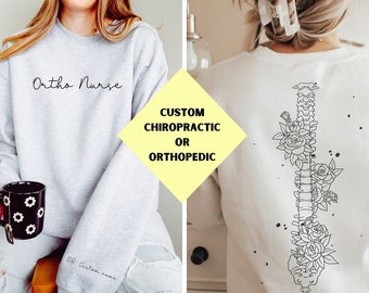 Pode incluir: Uma camisa de moletom cinza com o texto "Ortho Nurse" na frente e um nome personalizado na manga. A parte de trás da camisa de moletom apresenta uma ilustração em preto e branco de uma coluna vertebral com flores.