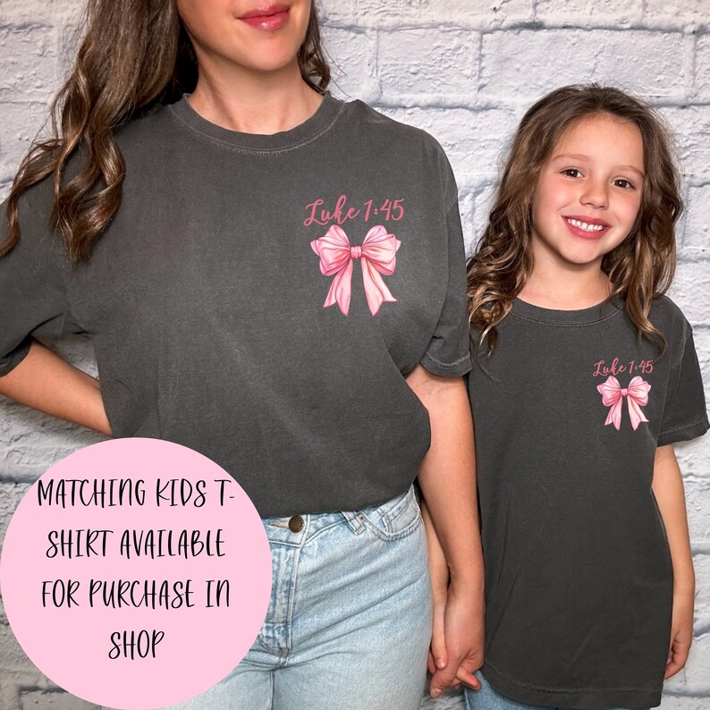 May include: Matching grey t-shirts with a pink bow and the text "Luke 1:45" on the front.