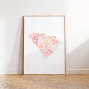 May include: A framed print of the state of South Carolina, outlined in pink, orange, and yellow swirls.