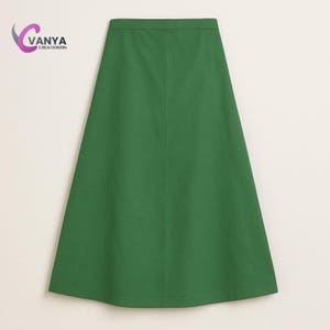 Puede incluir: Una falda verde de línea A con una costura central.