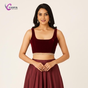 May include: A burgundy velvet crop top with a square neckline and a beaded fringe detail at the waist. The top is paired with a matching burgundy skirt. The image features the "Vanya Creationsin" logo in the upper left corner.