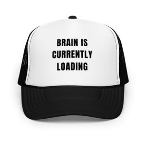 May include: Black and white trucker hat with a white front panel and black mesh back. The front panel has the text "Brain is currently loading" in black.