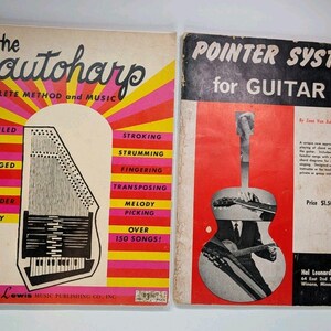 May include: Two vintage music instruction books. The left book is titled The Autoharp Complete Method and Music by Alexander Shealy, featuring a yellow and pink sunburst design. The right book is Pointer System for Guitar Book 1 by Izae Van Auken.