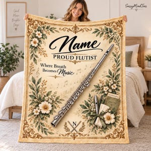 Peut inclure: Une couverture rectangulaire à fond crème ornée d'une grande flûte argentée, de bordures florales et de notes de musique. Le texte indique : Name, PROUD FLUTIST, Where Breath Becomes Music. Inclut une petite flûte et un livre intitulé FLUTE.