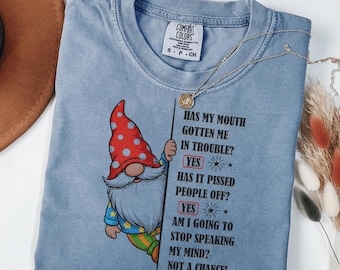 Peut inclure: T-shirt bleu jean Comfort Colors avec un motif de gnome et du texte. Le gnome porte un chapeau rouge à pois. Le texte dit : "Ma bouche m'a-t-elle causé des ennuis ? Oui. Ça a énervé les gens ? Oui. Vais-je arrêter de dire ce que je pense ? Pas question !"