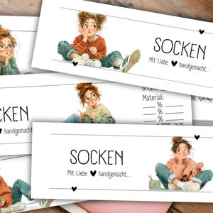 Könnte beinhalten: Mehrere weiße Karten mit dem Wort "SOCKEN" und dem Satz "Mit Liebe handgemacht" in Schwarz gedruckt. Jede Karte zeigt eine Illustration einer jungen Frau beim Stricken. Die Karten enthalten auch Felder für Größe und Materialprozentsätze.