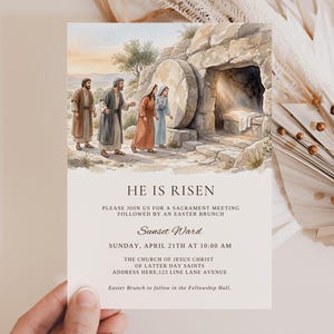Pode incluir: Um cartão de convite com uma ilustração em aquarela do túmulo vazio e figuras. O texto "HE IS RISEN" é exibido acima dos detalhes de uma reunião sacramental e um brunch de Páscoa. O cartão é segurado por uma mão.