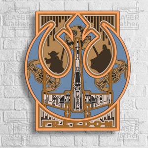 以下が含まれることがあります： スターウォーズをテーマにした、多層構造の木製ウォールアート。反乱同盟軍のシンボル、Xウイング戦闘機、ヨーダとダース・ベイダーのシルエットがデザインされています。「FREEDOM」の文字が下部にあります。