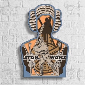 Puede incluir: Una silueta de papel recortada en capas que representa a la Princesa Leia de Star Wars. La silueta está en tonos de azul, marrón y naranja. El texto "STAR WARS" es visible en la parte inferior de la silueta.