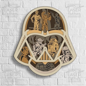 Könnte beinhalten: Ein mehrschichtiger Holzausschnitt von Darth Vaders Helm mit verschiedenen Star Wars-Charakteren im Inneren, darunter Yoda, R2-D2, Prinzessin Leia, Chewbacca, Han Solo und Boba Fett.