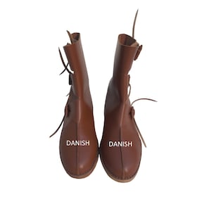 Könnte beinhalten: Ein Paar braune Lederstiefel mit Schnallen und Schnürsenkeln. Die Stiefel tragen den Schriftzug "DANISH".