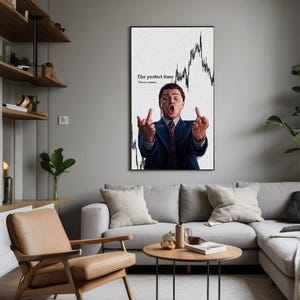 May include: A framed wall art print featuring a man in a suit gesturing with both middle fingers up. The background includes a stock market graph and the text "The perfect time. Never comes."