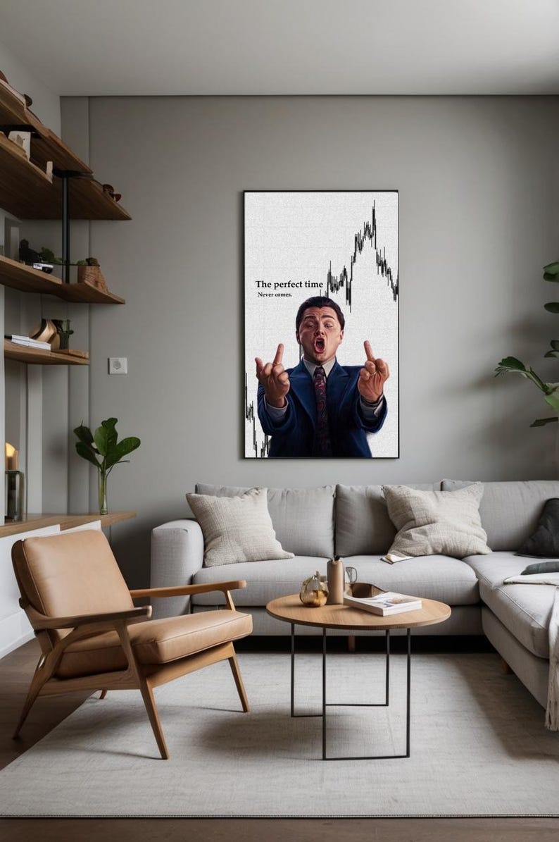 May include: A framed wall art print featuring a man in a suit gesturing with both middle fingers up. The background includes a stock market graph and the text "The perfect time. Never comes."