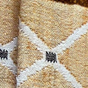 May include: Two beige woven placemats with white and black diamond patterns.