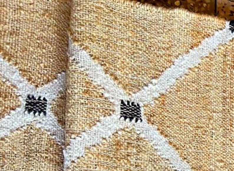 May include: Two beige woven placemats with white and black diamond patterns.