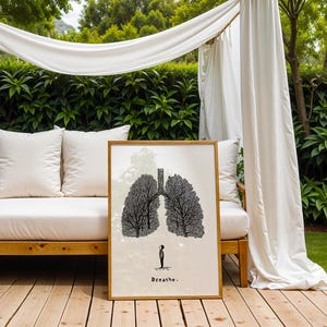 May include: A framed art print featuring a black and white illustration of lungs shaped like trees. A small figure stands below the lungs. The word "Breathe" is printed at the bottom. The artwork is displayed outdoors.