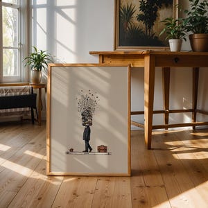 Puede incluir: Impresi&oacute;n art&iacute;stica enmarcada que presenta una ilustraci&oacute;n estilizada de una persona con una pila de libros en la cabeza, un malet&iacute;n y una taza peque&ntilde;a. La obra de arte est&aacute; en un marco de madera y sobre un fondo neutro. El tema general es intelectual y art&iacute;stico.