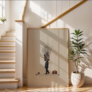Puede incluir: Una impresi&oacute;n art&iacute;stica enmarcada representa a una persona con una pila de libros en la cabeza, caminando con un malet&iacute;n. La obra de arte tiene una paleta de colores neutros, con un fondo beige claro y un marco de madera. Una planta en maceta blanca est&aacute; en primer plano.