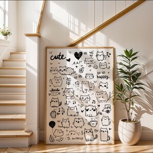 Puede incluir: Un cuadro enmarcado con ilustraciones de gatos en blanco y negro. La palabra "cute" está escrita en la parte superior, junto con la frase "so so happy". La obra de arte se exhibe en una habitación luminosa con una escalera y una planta en maceta.